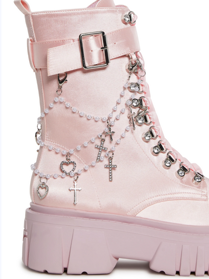 Angelcore Mayhem Boots with chunky platforms, shiny satin build, adjustable ribbon laces, buckle straps, side zippers, and removable beaded straps with cross and heart charms.