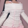 White sweater with two satin ribbons down the front and a bow on each side at the bottom for a delicate touch.