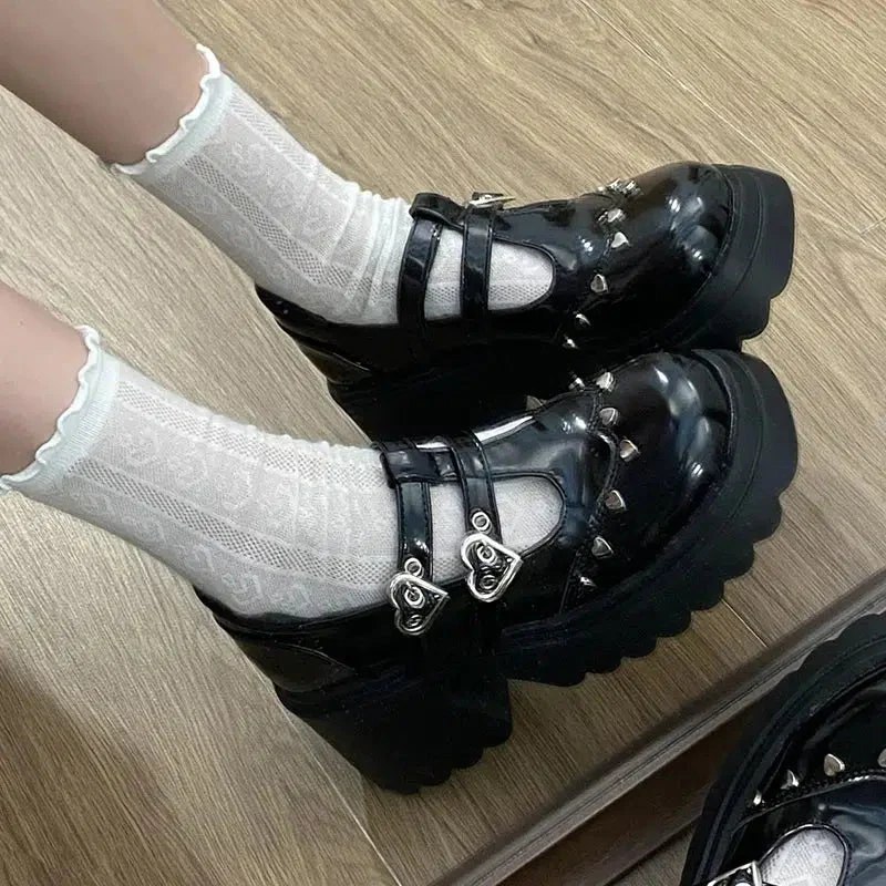 Black Mary Jane shoes with platform on the foot, showcasing their elegant design with heart-shaped buckles and fastenings, offering a stylish and comfortable look