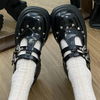 Front view of the black Mary Jane shoes with platform, showcasing delicate details of small metallic hearts around the shoe, adding a cute and sophisticated touch to the design