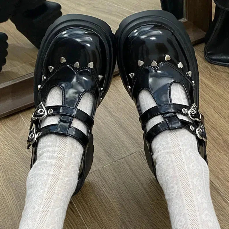Front view of the black Mary Jane shoes with platform, showcasing delicate details of small metallic hearts around the shoe, adding a cute and sophisticated touch to the design
