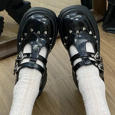 Front view of the black Mary Jane shoes with platform, showcasing delicate details of small metallic hearts around the shoe, adding a cute and sophisticated touch to the design