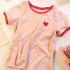 Pink tee with a small red heart, offering a cute and simple style for a sweet look.