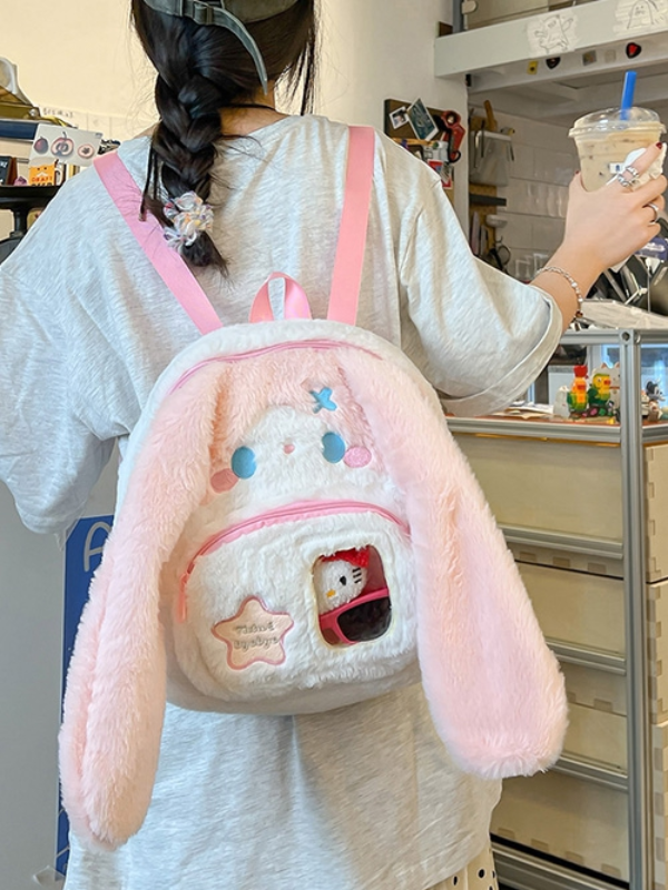 Pink backpack shown from the front, worn on the back of a model, featuring a transparent pocket where you can place a photo of your loved one or favorite character, adding a personal and unique touch to the design.
