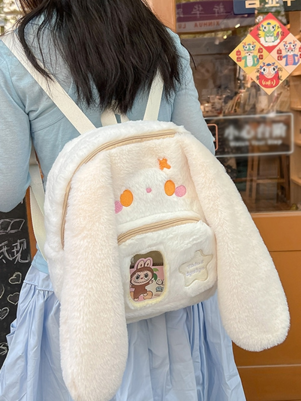 Beige backpack shown from the front, worn on the back of a model, offering a modern and practical look with a touch of elegance.