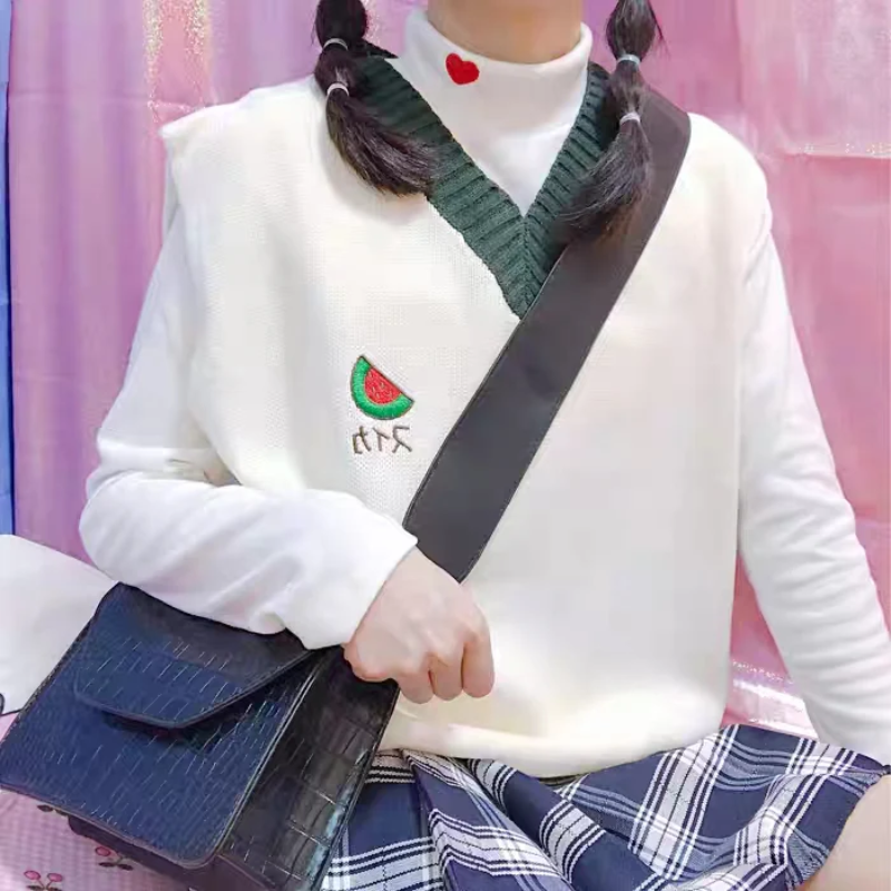 White sweater with a green collar and a cute watermelon embroidery, adding a fresh and playful touch.